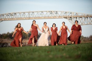 bride holding hands with bridesmaids