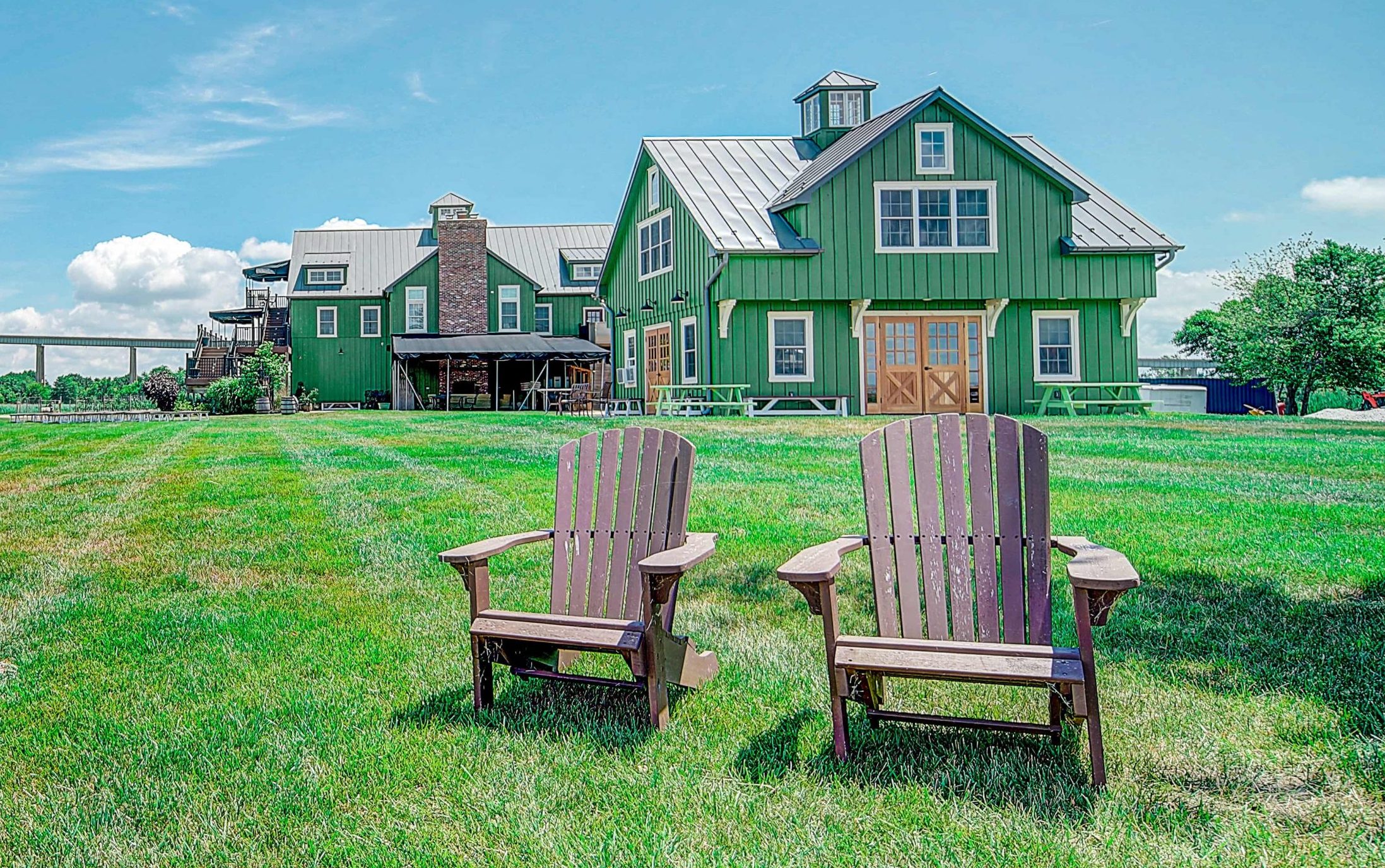 Two Wooden chairs in front of the barn | Thousand Acre Farm